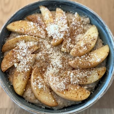 Porridge mit fächerförmig gelegten Apfelspalten und gemahlenen Mandeln