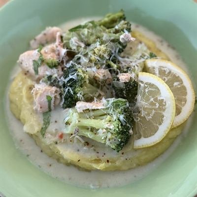 Lachs und Brokkoli in heller Soße auf Kartoffelbrei mit Zitronenscheibe