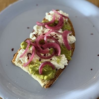 Bauernbrot mit Guacamole, körnigem Frischkäse und eingelegten roten Zwiebeln