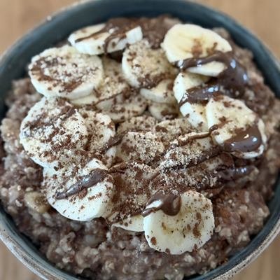 Schoko-Porridge mit Bananenscheiben, Kakao und Nussmus