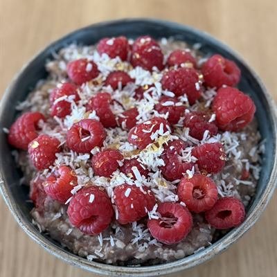 Schoko-Porridge mit frischen Himbeeren und Kokosraspeln