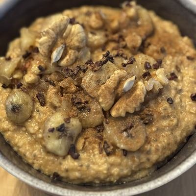 Kürbis-Porridge mit Walnüssen, Bananenscheiben und Kakaonibs