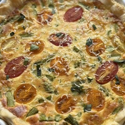 Spargel-Quiche mit Cocktailtomaten in einer Tarteform