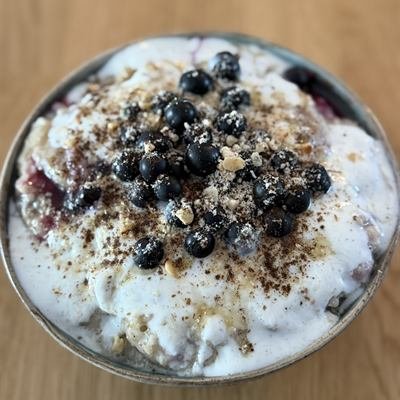 Vanille-Porridge mit Joghurt, schwarzen Johannisbeeren und gemahlenen Mandeln